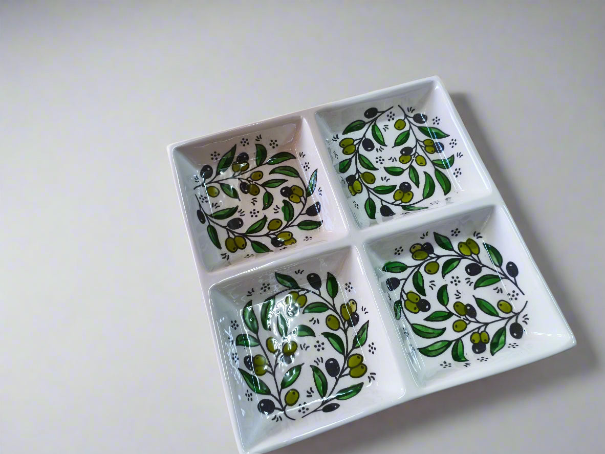 Ceramic dish with green leaf patterns on a wooden surface
