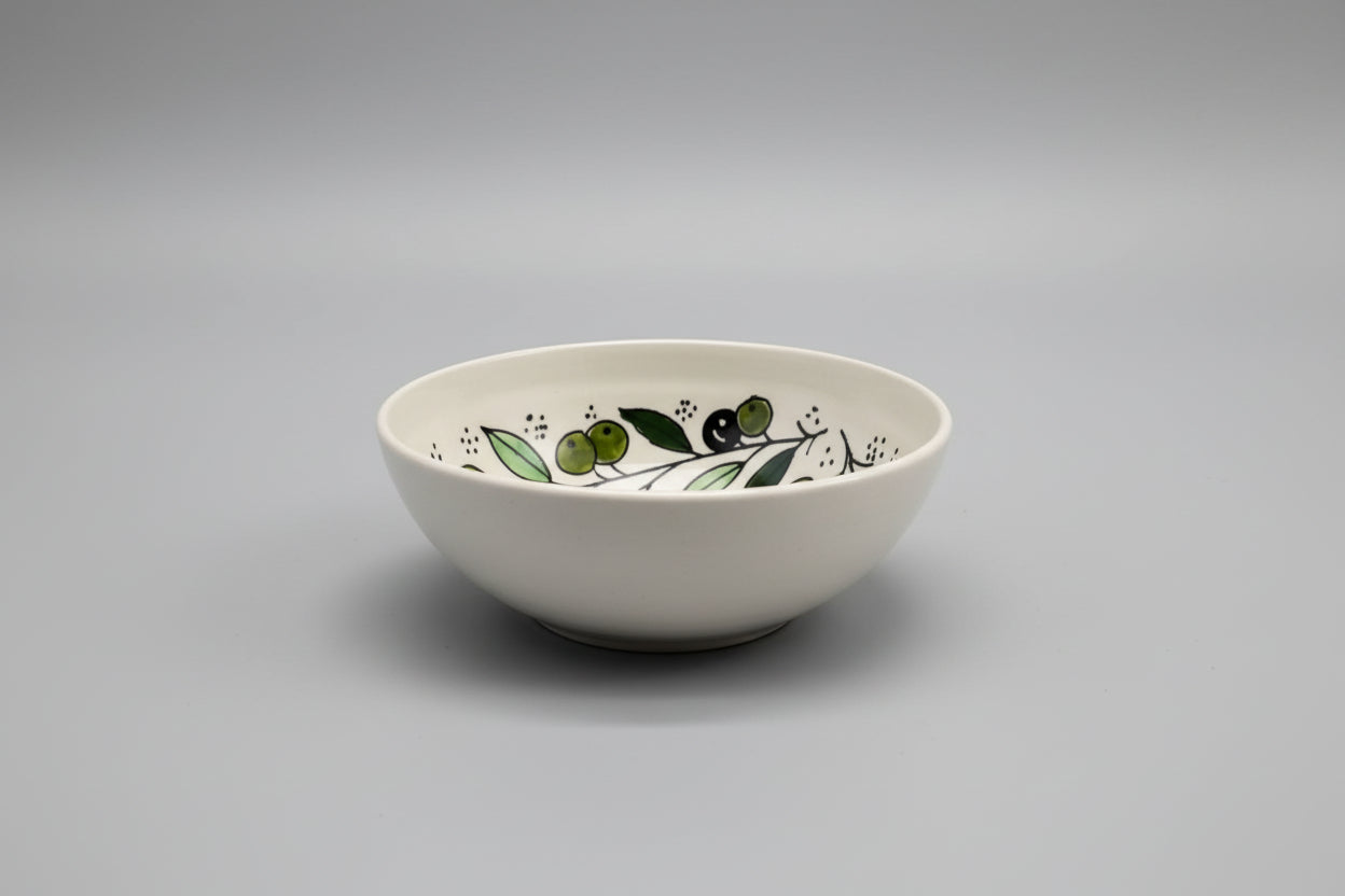 Ceramic bowl with olive design on a gray surface