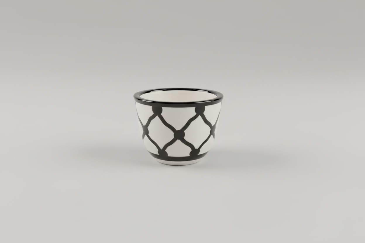 Black and white ceramic cup on a wooden floor with blurred background