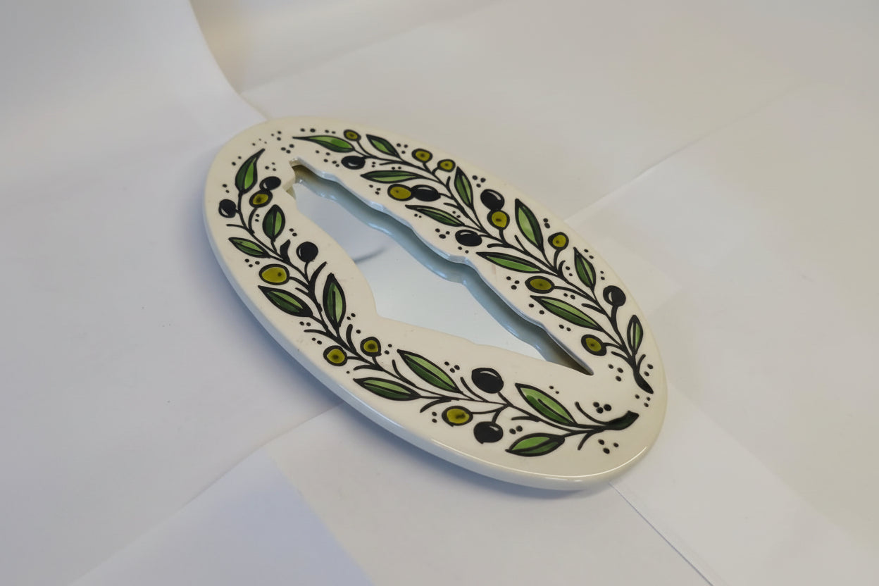 Decorative letter 'O' with green leaf pattern on a white background