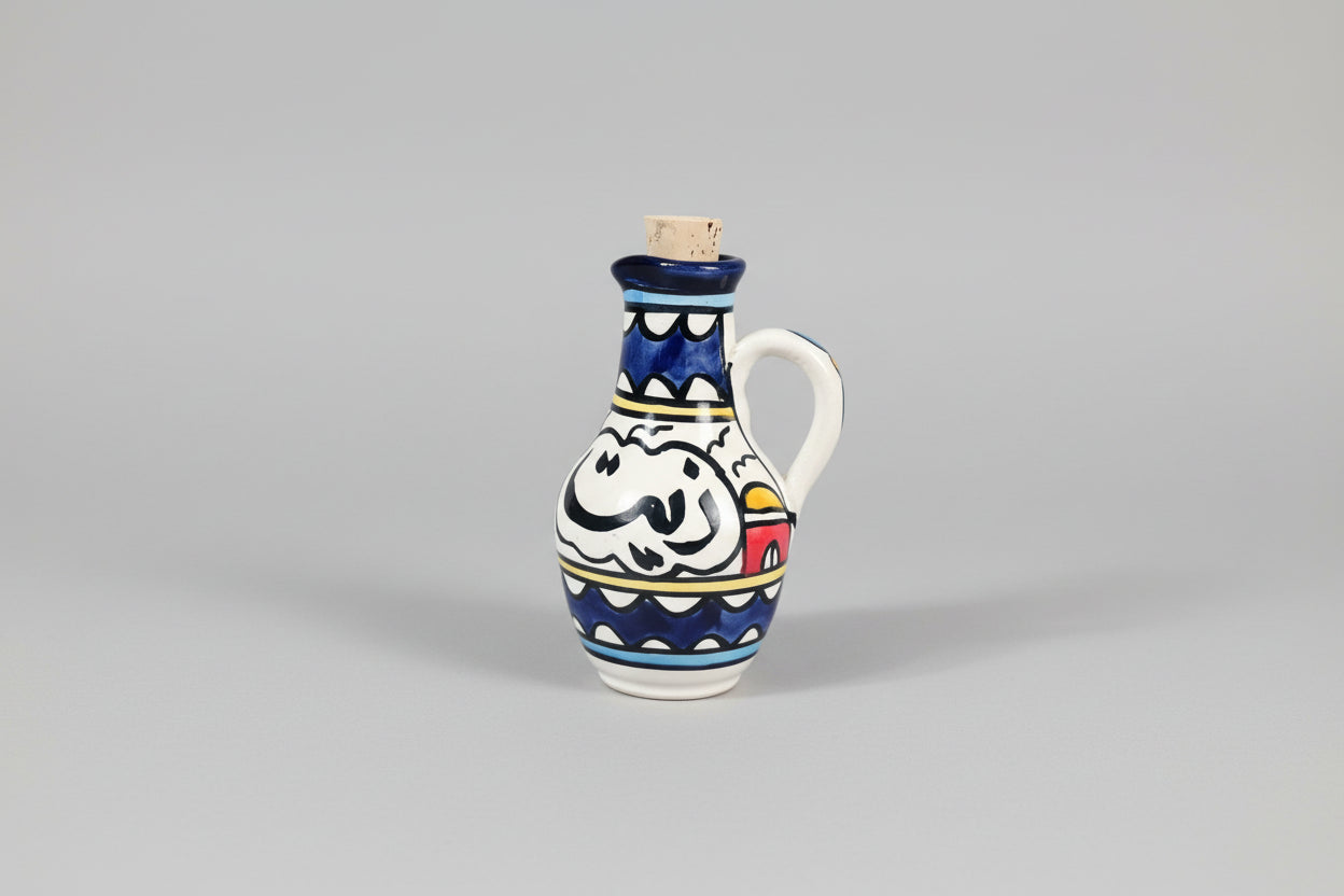 Decorative ceramic oil bottle with colorful design on a wooden floor.