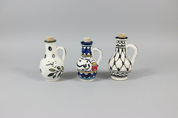 Three ceramic bottles with decorative patterns on a wooden floor.