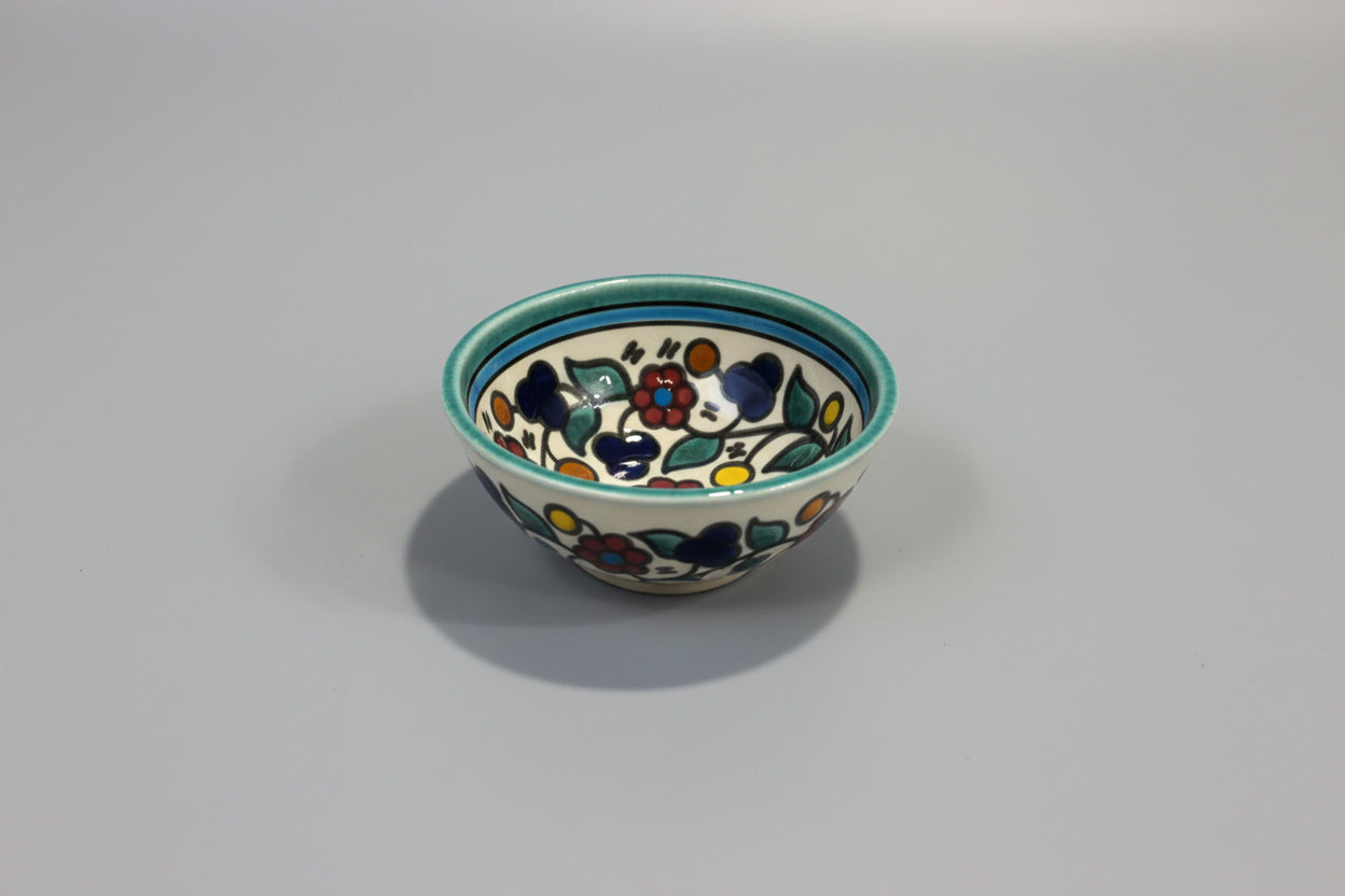 Small ceramic bowl with floral design on a gray surface