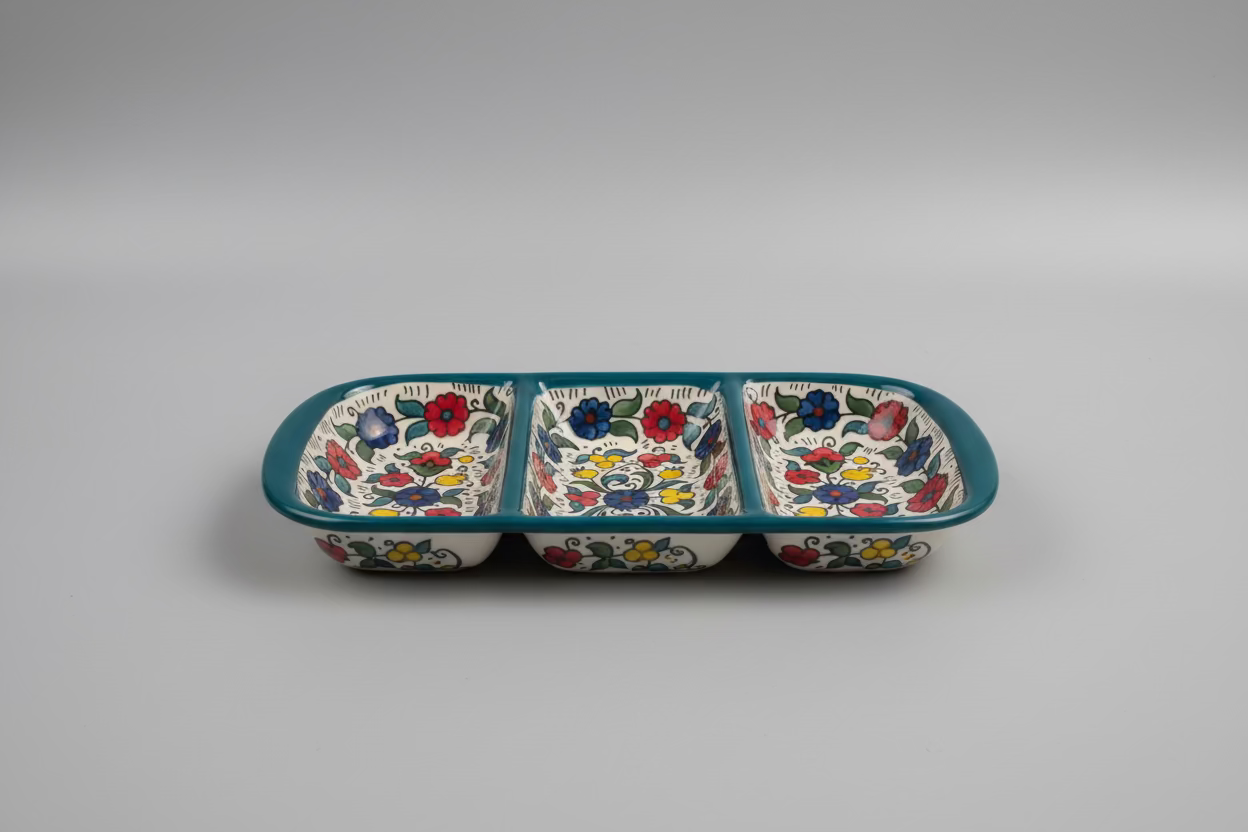 Three-section ceramic tray with floral patterns on a wooden surface