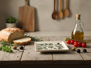 Square ceramic plate with olive branch design on a white surface